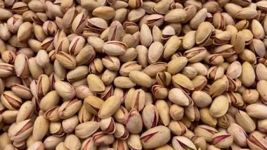 Kabuklu fıstıkların gerçekçi hareket videosu sade bir ortamda, beslenme, vegan atıştırmalıkları veya kuru meyve pazarlarını temsil etmek için mükemmeldir..