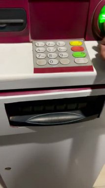 Bir banka işlemi bir el bir kart yerleştirir ve bir ATM makinesinden para toplar.