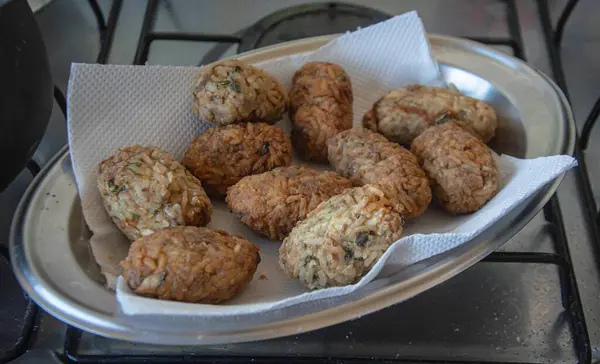 Kızarmış pirinç toplarıyla dolu çelik bir tabak.