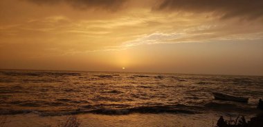 Bu büyüleyici görüntü sakin bir denizin üzerinde altın bir günbatımının huzurlu güzelliğini yakalar. Gökyüzü sıcak turuncu ve altın tonlarıyla boyanır, suyun üzerine dingin ve ruhani bir ışık yayar..