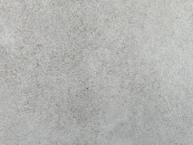 Grunge Scratched Gray Beton Duvarı Arka planı. Tırmalanmış ve yıpranmış beton duvar yüzeyinin pürüzlü gri grunge dokusu. Arka planda, üstüste, inşaat temalarında, kentsel tasarım projelerinde, grunge-style düzenleme ve dijital dokularda kullanım için idealdir.