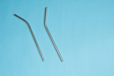 Mavi arkaplana kurulmuş metal pipetler paslanmaz çelik pipetle içmek için plastik pipetlerin kullanımını azaltmak için çevre dostu araçlar 