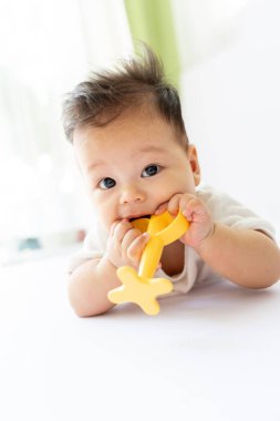 Bir bebek ağzında muz tutuyor.