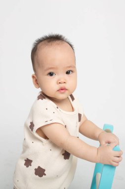 Bir bebek mavi sandalyede oturuyor.