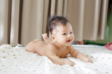 Yatağın üstünde yatan bir bebek.