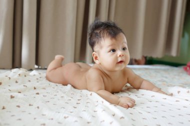 Yatağın üstünde yatan bir bebek.