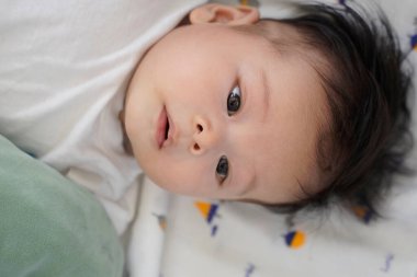 Yatakta yatan bir bebeğin yakın çekimi.