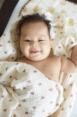 Battaniyeye sarılı yatağın üzerinde yatan bir bebek.