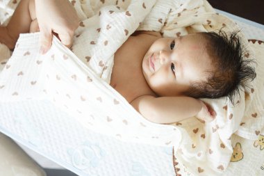 Yatağın üstünde yatan bir bebek.