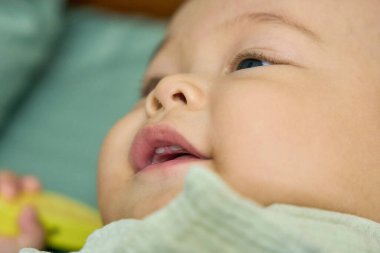 Yatakta yatan sevimli, gülümseyen yeni doğan bebeğin portresi.