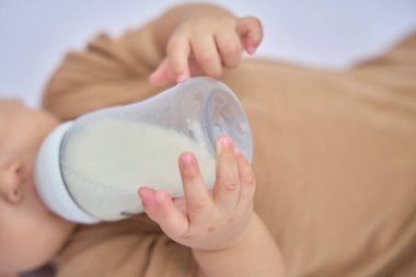 Bebeğin elini kapat, bebeğin elini kapat, şişeyi tek eliyle tut.