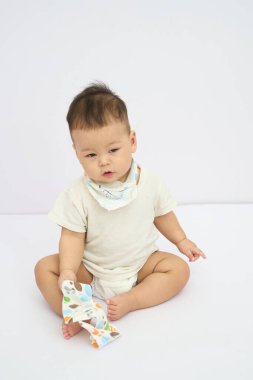 Bir bez parçası ile yerde oturan bir bebek