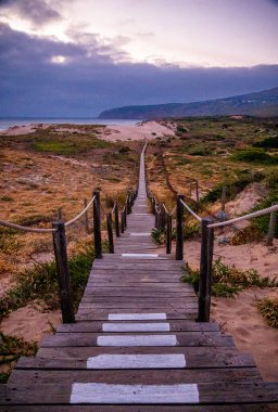 Kumsaldan denize uzanan kahverengi merdivenler, bulutlu bir günde