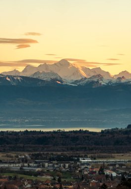 Mont Blanc, batı Avrupa 'nın en yüksek dağı, kış günbatımının altın saatinde, İsviçre kırsalında ve Cenevre Gölü manzaralı