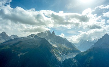 Fransız Alplerindeki La Mer de Glace 'in panoramik manzarası güneşli bir günde bulutlar ve mavi gökyüzü