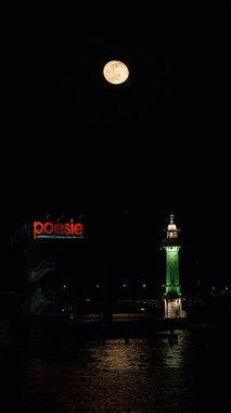 A full moon at night illuminates the Bains des Paquis and its lighthouse in Geneva, with the moon reflection shimmering on Lake Geneva clipart