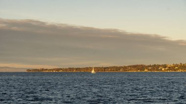  Günbatımında Cenevre yakınlarında Geneva Gölü 'nün sularında bir yelkenli süzülüyor.