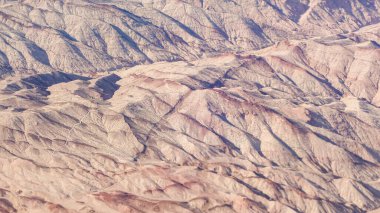 Çöl yukarıdan engebeli dağlarını ve çorak arazisini gözler önüne seriyor.