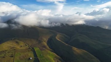 Ekvador 'da güneş doğarken insansız hava aracı aşırı hızlanıyor. Karla kaplı Cayambe volkanı bulutların hızlı hareket etmesiyle ortaya çıkar. Sıcak güneş ışığı içinden geçer.. 