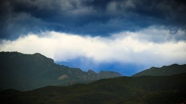 Corsican mountains and dramatic clouds in France clipart