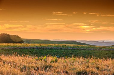 Aubrac dağlarında akşam manzarası. Fransa 'nın merkezinde taş ve kaya duvarları olan güzel bir bahar akşamı..