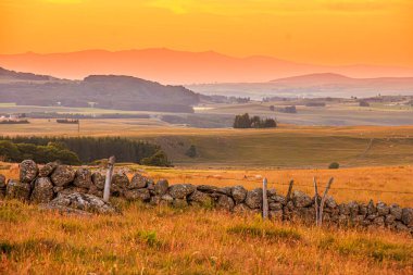 Aubrac dağlarında akşam manzarası. Fransa 'nın merkezinde taş ve kaya duvarları olan güzel bir bahar akşamı..