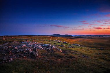 Aubrac dağlarında akşam manzarası. Fransa 'nın merkezinde taş ve kaya duvarları olan güzel bir bahar akşamı..