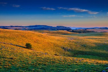 Aubrac dağlarında akşam manzarası. Fransa 'nın merkezinde taş ve kaya duvarları olan güzel bir bahar akşamı..
