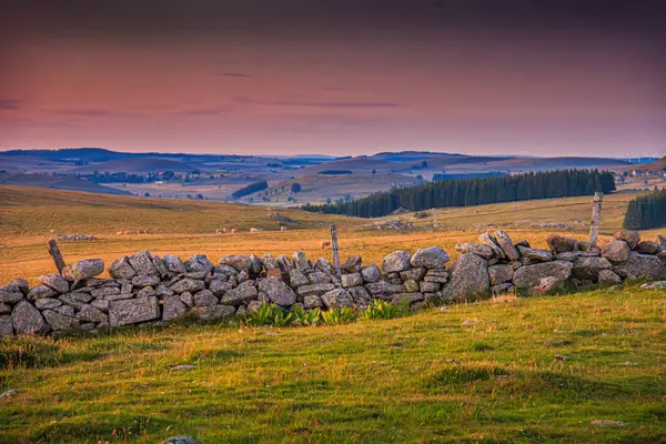 Aubrac dağlarında akşam manzarası. Fransa 'nın merkezinde taş ve kaya duvarları olan güzel bir bahar akşamı..