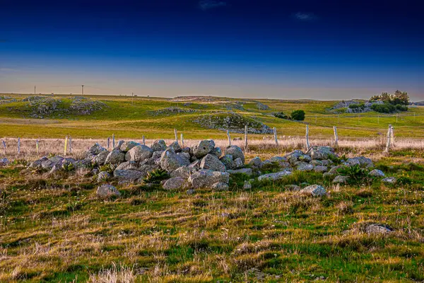 Aubrac dağlarında akşam manzarası. Fransa 'nın merkezinde taş ve kaya duvarları olan güzel bir bahar akşamı..