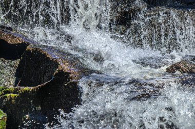 Alzeau nehrinin manzarası Saint Denis barajının altında. Yazın Fransa 'nın güneyindeki yeşilliğin ortasında bir kayanın üzerinde şelale..