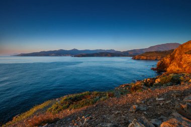 Fransa 'nın güneyindeki Port Vendres' te kayalarla çevrili denize yansıyan Cap Bar 'da, Katalan topraklarında gün doğumu.. 