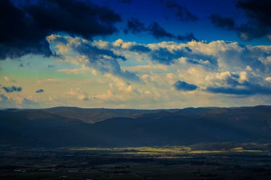 Aude bölgesindeki Alaric Dağı 'nın tepesinden rüzgar türbinleri görüldü. Güney Fransa 'da Occitanie' de bulutlar tarafından yontulmuş güneş ışınlarıyla çevrili manzaralar..