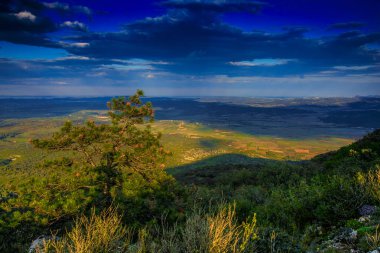 Aude bölgesindeki Alaric Dağı 'nın tepesinden rüzgar türbinleri görüldü. Güney Fransa 'da Occitanie' de bulutlar tarafından yontulmuş güneş ışınlarıyla çevrili manzaralar..