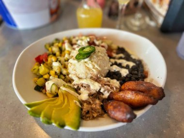 Lezzetli muz ve ızgara mısır içeren canlı bir tabak Meksika yemeği geleneksel mutfağın özünü renkli ve iştah açıcı bir sunumla yakalıyor..