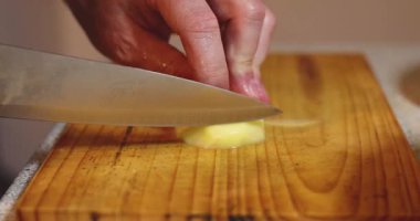 Tahtadaki bıçakla patatesleri ince dilimlere ayır..