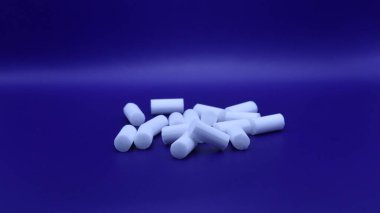 Siyah arka planda beyaz plastik haplar