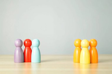 Gri arkaplandaki insanların renkli ahşap figürleri