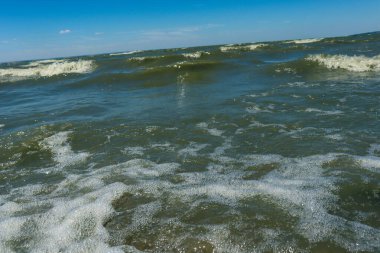 Güzel mavi deniz dalgaları ve beyaz bulutlar mavi gökyüzüne karşı, küçük fırtına