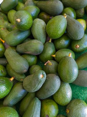 Yerel pazar. Alıcının elleri. Avokado tezgahta.