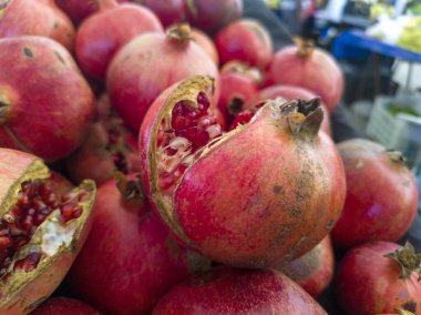 Yerel pazar. Tezgahta nar, koyu kırmızı renklerini ve doğal dokularını sergiliyorlar. Sağlık ve beslenme temaları için ideal.
