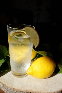 Bir bardak buzlu limonlu, koyu arkaplan buzlu, beyaz limonlu, sağlıklı içecekler. Kokteyl tazeleniyor