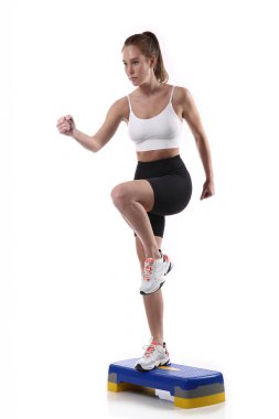 Çekici, formda bir kadın. Stüdyoda fotokopi odasıyla egzersiz yapıyor. Beyaz arka planda spor yapan sağlıklı genç bayan sporcu görüntüsü.