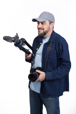 Modern dijital SLR kameralı erkek fotoğrafçı ve beyaz arka planda izole edilmiş üç ayaklı.