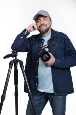 Modern dijital SLR kameralı erkek fotoğrafçı ve beyaz arka planda izole edilmiş üç ayaklı.