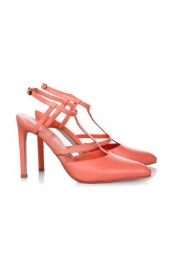 Beyaz arka planda bir çift turuncu kadın topuklu ayakkabısı.