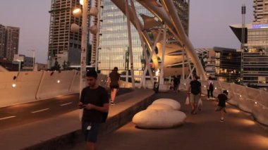 Tel Aviv, İsrail - 14 Ağustos 2024. Akşam Tel Aviv 'in merkezinde yaya köprüsü var. İnsanlar yürüyor ve bisiklete biniyor.
