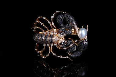 Women s bracelet made of gold and black diamonds in the form of a huge scorpion on a black background. Designer jewelry clipart