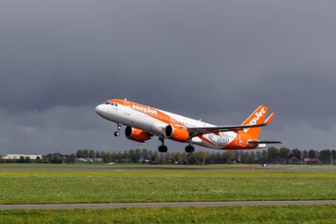 Schiphol, Hollanda - 17 Nisan 2024. Easyjet Airbus A320 bulutlu bir yağmurlu günde pistten havalanıyor. 