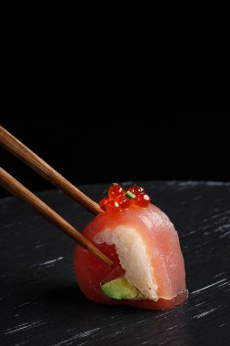 Ellerinde çubuklarla suşi sarması yemek, suşi sarması yemek, Japon restoranında suşi yemek...